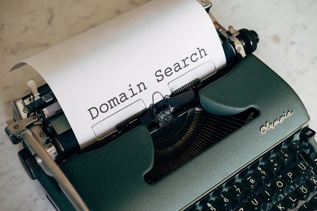 A vintage typewriter prints the words Domain Search on white paper, echoing the idea of a keyword-rich domain and online identity for ITJI.